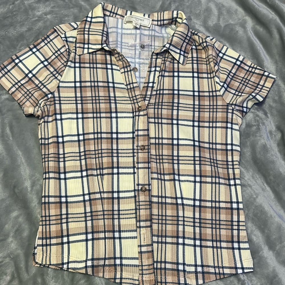 Flannel tan white black grey. It buttons.